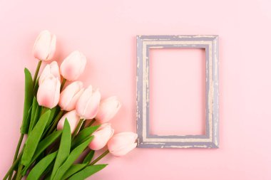 Anneler Günü 'nüz kutlu olsun. Üst görünüm düz fotoğraf çerçevesi ve pembe zemin üzerinde lale çiçeği, metin için kopyalama alanı