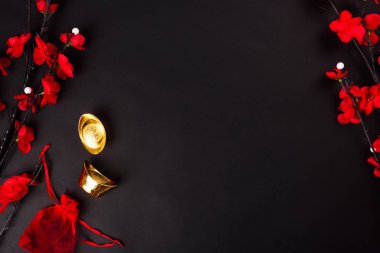Çin Yeni Yılı, düz üst görünüm, altın külçe ve Çin Çiçeği siyah zemin üzerinde metin alanınız için fotokopi alanı