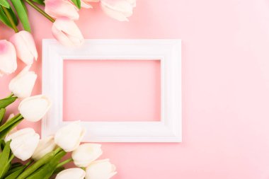 Anneler Günü 'nüz kutlu olsun. Üst görünüm düz lale çiçeği ve pembe arkaplanda fotoğraf çerçevesi, metin için boşluk kopyala