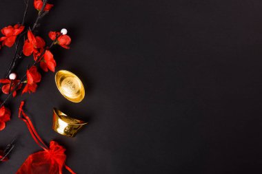 Çin Yeni Yılı, düz üst görünüm, altın külçe ve Çin Çiçeği siyah zemin üzerinde metin alanınız için fotokopi alanı
