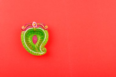 Mutlu bayramlar, Düz görünüm kırmızı arka planda renkli Clay Diya lambaları ve metin alanınız için kopyalama alanı