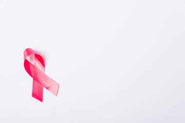 Göğüs kanseri ay konsepti, düz üst görünüm, beyaz zemin üzerinde pembe kurdele ve metin alanınız için kopyalama alanı
