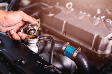 Otomotiv teknisyeninin eli soğutucu suyu kontrol ediyor. 