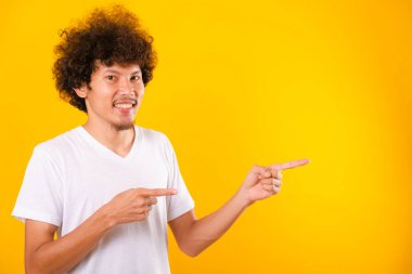 Asian Portrait happy young man curly hair pointing fingers away 