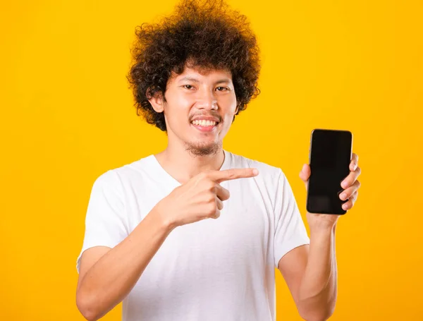Feliz asiático guapo joven hombre con rizado cabello holding en blanco scr — Foto de Stock