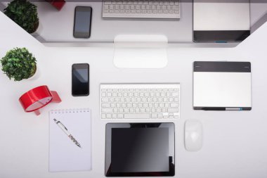 Üst görünüm Ofis monitörü beyaz masadaki bilgisayar retina görüntüsü, fare, klavye, cep telefonu, tablet ve boş ekran