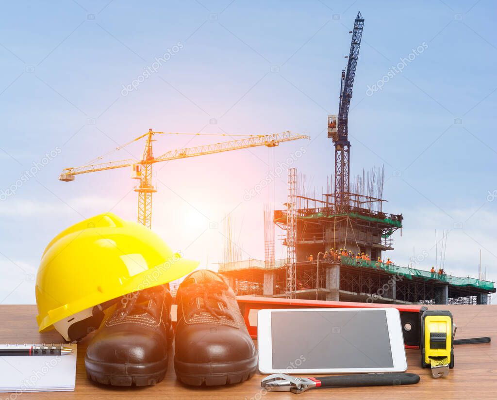 Working table engineer with tablet and tools in building construction crane