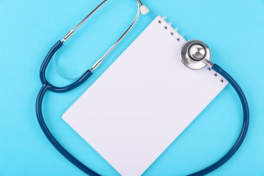 Doctor 's Day konsepti, düz üst görünüm, peper notalı steteskop mavi arka planda kalp rahatsızlığı teşhisi ve metin için metin alanı
