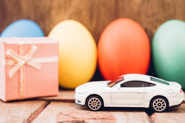 Telur Paskah dan mobil mainan dengan latar belakang kayu , — Stok Foto