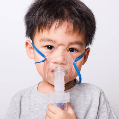 Kapalı Asyalı yüz, küçük çocuk hasta buhar spreyi nebulizer maskesi kullanıyor beyaz arka planda kendini soluyor, sağlık hizmetleri...