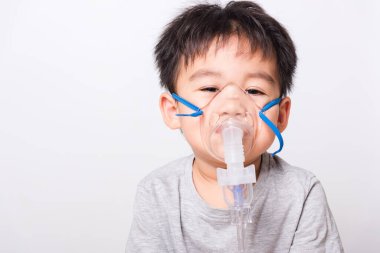 Kapalı Asyalı yüz, küçük çocuk hasta buhar spreyi nebulizer maskesi kullanıyor beyaz arka planda kendini soluyor, sağlık hizmetleri...