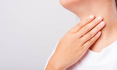 Asyalı güzel kadın Boğaz Ağrısı veya tiroid bezi sorunu. Beyaz arka planda, kopyalama alanı, tıbbi ve sağlık hizmetleri konseptiyle El Dokunma Hastalığı Boynunu kullanıyor.