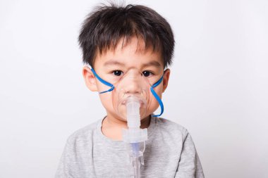 Kapalı Asyalı yüz, küçük çocuk hasta buhar spreyi nebulizer maskesi kullanıyor beyaz arka planda kendini soluyor, sağlık hizmetleri...