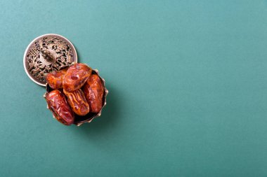 Ramadan, Dates in golden bowl and have arabian Aladdin golden lamp vintage style on black green background