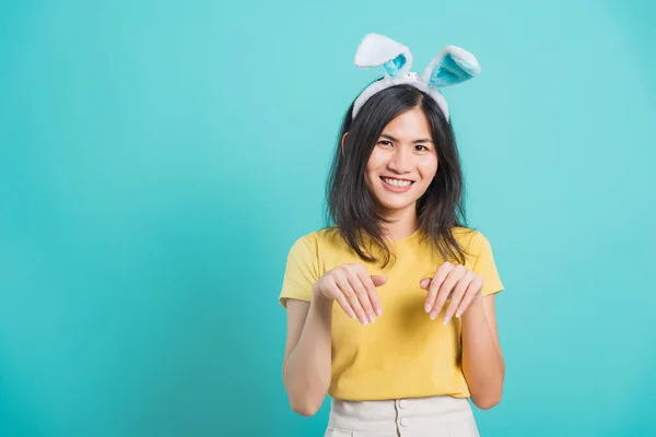 肖像画アジアの美しい幸せな若い女性の笑顔白い歯は コピースペースと青の背景に ウサギの耳を使用して立って黄色のTシャツを身に着けています — ストック写真