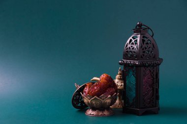 Ramazan Kareem oruç tutuyor Yemek Kavramı, Bronz tabak tarihleri ve fener Aladdin lamba süslemesi, Arap bayramı dini festivali koyu yeşil arka planda metin alanı ile