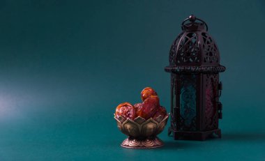 Ramazan Kareem oruç tutuyor Yemek Kavramı, Bronz tabak tarihleri ve fener Aladdin lamba süslemesi, Arap bayramı dini festivali koyu yeşil arka planda metin alanı ile