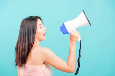 Smiling face portrait asian beautiful woman her usring megaphone on blue background, with copy space for text