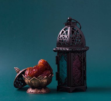 Ramazan Kareem oruç tutuyor Yemek Kavramı, Bronz tabak tarihleri ve fener Aladdin lamba süslemesi, Arap bayramı dini festivali koyu yeşil arka planda metin alanı ile