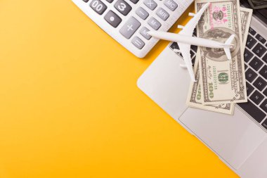 Yılın Nisan ayı Vergi Günü, Üst görünüm dairesi yakın çekim hesap makinesi, dizüstü bilgisayar ve dolar parası, metin için metin alanı ile sarı arka plan iş bütçesi konsepti