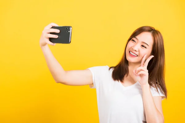아시아인 사진아름다운 귀여운 소녀가 웃으며 소녀는 티셔츠를 사진을 스마트폰에서 비디오 — 스톡 사진