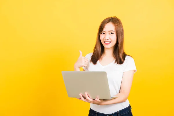 아시아인 아름다운 귀여운 소녀웃는 소녀가 노트북 컴퓨터를 사용하여 티셔츠를 바라보고 — 스톡 사진