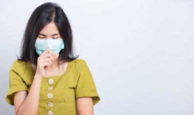 Yüz maskesi takan Asyalı güzel güzel bir kadın filtre tozu pm2.5 anti kirlilik, anti-duman ve hava kirliliğini koruyor. Beyaz arka planda hapşırması, fotokopi alanı ile birlikte.