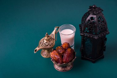 Ramazan Kareem oruç tutuyor Yemek Kavramı, Bronz tabak günleri, süt ve fener Aladdin lamba süslemesi, bayram Arap Müslüman dini festivali koyu yeşil arka planda metin alanı ile birlikte
