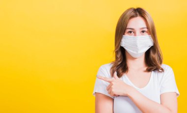 Yüz maskesi takan Asyalı güzel bir kadın filtre tozu pm2.5 anti-kirlilik, anti-duman, hava kirliliği ve COVID virüsünü koruyor.