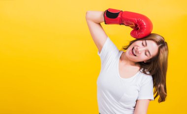 Asyalı güzel bir kadının portresi kırmızı boks eldivenleriyle gülümsüyordu. Kafasını ve gözlerini kapatıyordu. Stüdyoda fotoğraf çekiliyordu.