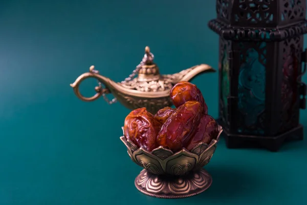 ラマダーンカレーム断食食の概念 ブロンズプレートの日付 提灯アラジンランプの装飾 テキストのためのコピースペースを持つ暗い緑の背景にイスラム教徒の宗教的な祭り — ストック写真