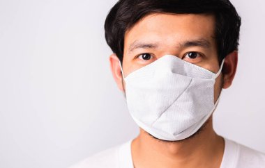 Coronavirus 'a karşı cerrahi hijyenik koruyucu yüz maskesi takan Asyalı yakışıklı adam, izole edilmiş beyaz arka plan, COVID-19 tıbbi konsept.