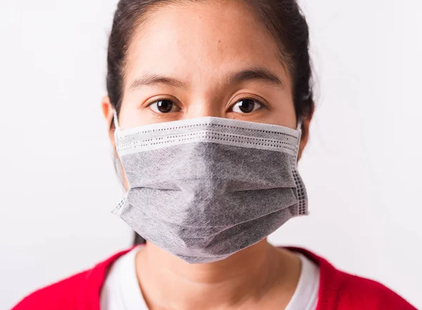 Closeup Asian adult woman wearing red shirt and face mask protective against coronavirus, COVID-19 virus or filter dust pm2.5 and air pollution she looking camera studio shot isolated white background