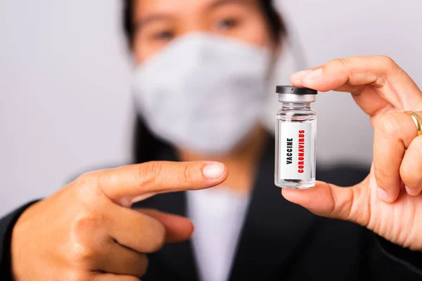 亚洲女医生戴着外科防护布面罩对抗考拉韦病毒 她的针尖安布瓶疫苗专注于玻璃病毒标签 工作室拍摄孤立的白色背景 Covid — 图库照片