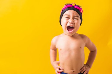 Yaz tatili konsepti, Asyalı mutlu çocuk portresi, gözlüklü ve bikinili çocuk, yaz tatilinde eğlenen çocuk, izole edilmiş sarı arka plan.
