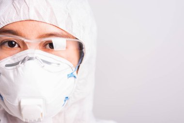 Laboratuvarda N95 koruyucu ve gözlük takan PPE süit üniformalı doktor ya da bilim adamının portre yüzü, koronavirüs ya da COVID-19 kavramı izole edilmiş beyaz arka plan