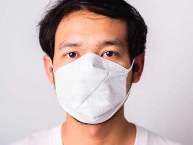 Coronavirus 'a karşı cerrahi hijyenik koruyucu yüz maskesi takan Asyalı yakışıklı adam, izole edilmiş beyaz arka plan, COVID-19 tıbbi konsept.