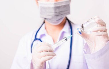 Kadın doktor, hemşire ya da üniformalı bilim adamı laboratuvar ortamında maske takıyor. Aşı şişesine şırınga enjekte ediyor. Tıbbi salgın Coronavirus COVID-19 kavramı.