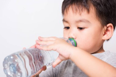 Kapalı Asyalı yüz, plastik şişeden su içen küçük çocuk beyaz arka planda fotokopi alanı, sağlık hizmetleri