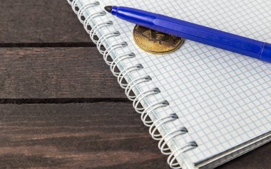 ahşap arka plan üzerinde beyaz dizüstü marker ve bitcoin lay