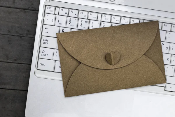 L'enveloppe et l'ordinateur portable reposent sur la table grise . — Photo