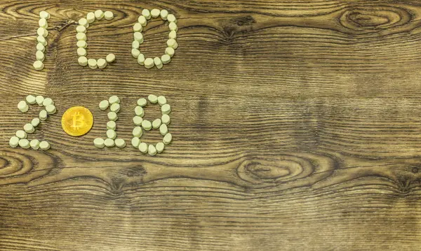 ICO 2018 metin ve altın bitcoin sikke lokum şekerleme ahşap arka plan üzerinde oluşmuştur.