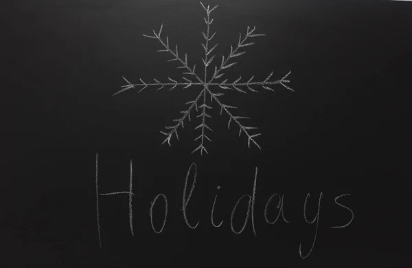 Ciągnione śnieżynka na tablica z tekstem: wakacje. — Zdjęcie stockowe