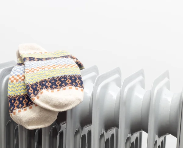 horizontal view for oil heater drying pair of light brown socks on white background.