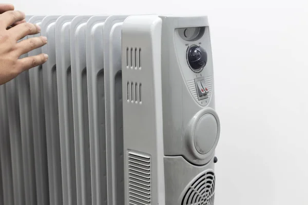 adam beyaz arka plan üzerinde sıcak almak için yağ ısıtıcı için ellerini bırakır.