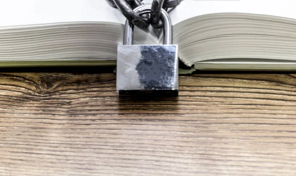 Livro aberto com corrente e bloqueio na mesa de madeira . — Fotografia de Stock