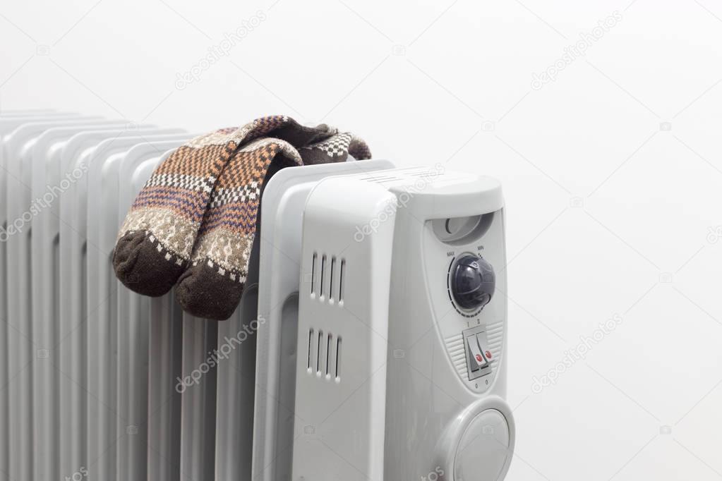 oil heater drying pair of brown socks on white background.