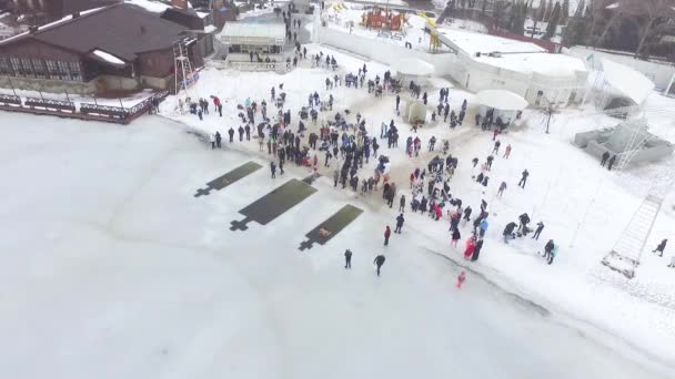 男と女が穴に飛び込む 水を祝福の儀式中にバルク入浴 エピファニーの宗教的な休日 空中展望空気 — ストック動画