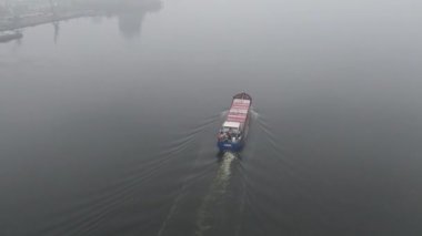 Su yüzeyinde yüzen hurda metal ve atıklarla dolu bir mavna. Kuru bir kargo gemisi vasıtasıyla geri dönüşümlü malzeme taşımacılığı. Gökyüzü panoramik görüntüsü uçan insansız hava aracı..
