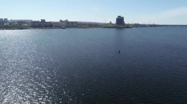 Şehir nehrinin üzerinden naklediliyor. Arabalar her iki yönde de köprüde hareket ediyor. Nehir üzerinde karayolu köprüsünde giden araba panoramik üstten görünüşü gökyüzü yüksekliği, helikopter dronu.